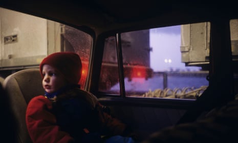 A child sitting in a backseat and looking through the window