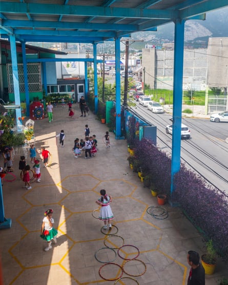 Children playing outside with a smoggy neighborhood and hills seen in the background