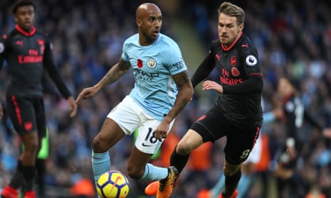 Manchester City’s Fabian Delph gets past Aaron Ramsey during the Premier League match against Arsenal on Sunday.