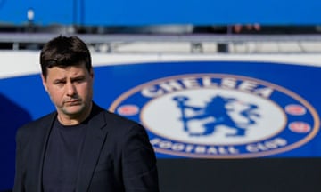 Mauricio Pochettino stands in front of a Chelsea badge.