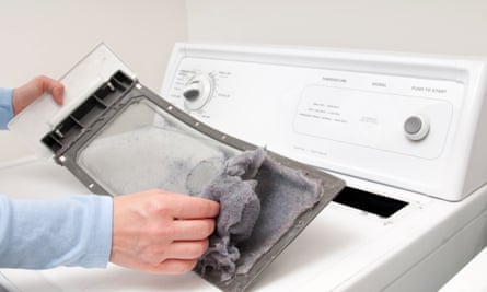 A person cleaning lint from a lint trapper
