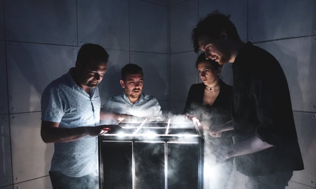 A team of four, in a dark room, play the escape room game Escapologic, Nottingham and Leicester.