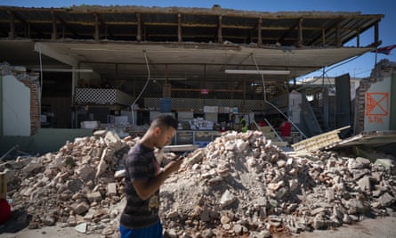 A man walks past a destroyed store after a 6.4 earthquake hit on Tuesday in Guánica, Puerto Rico.