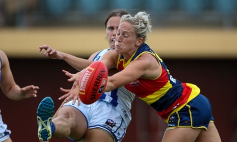 North Melbourne’s Jasmine Garner snaps a goal despite Marijana Rajcic’s attempted intervention during the Adelaide Crows’ win over the Kangaroos on Sunday.