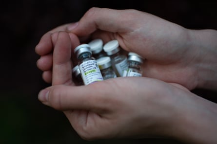 Hands cupping several small vials of testosterone