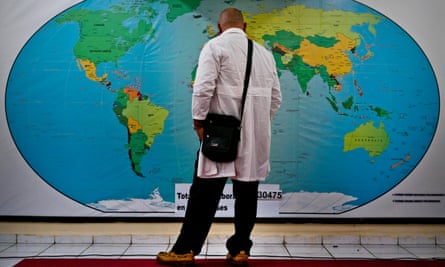 Cuban doctor Ralfis Carbort looks at a map of the world before leaving to help with the devastation caused by Hurricane Idai.