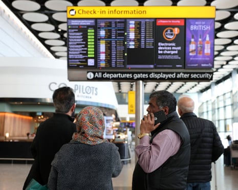 Travellers checking a departure board displaying cancelled flights to Middle East countries at Heathrow airport on Monday