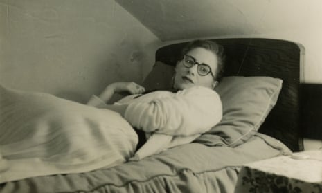 A young Monica Jones lies on a bed.