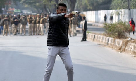 An unidentified man brandishes a gun during a protest against a new citizenship law outside the Jamia Millia Islamia university in New Delhi.