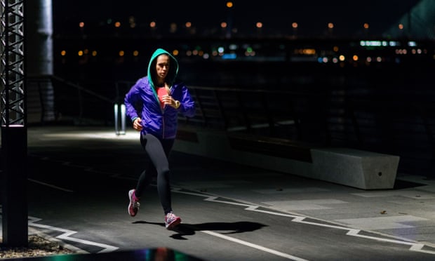 A woman jogging in the city at night