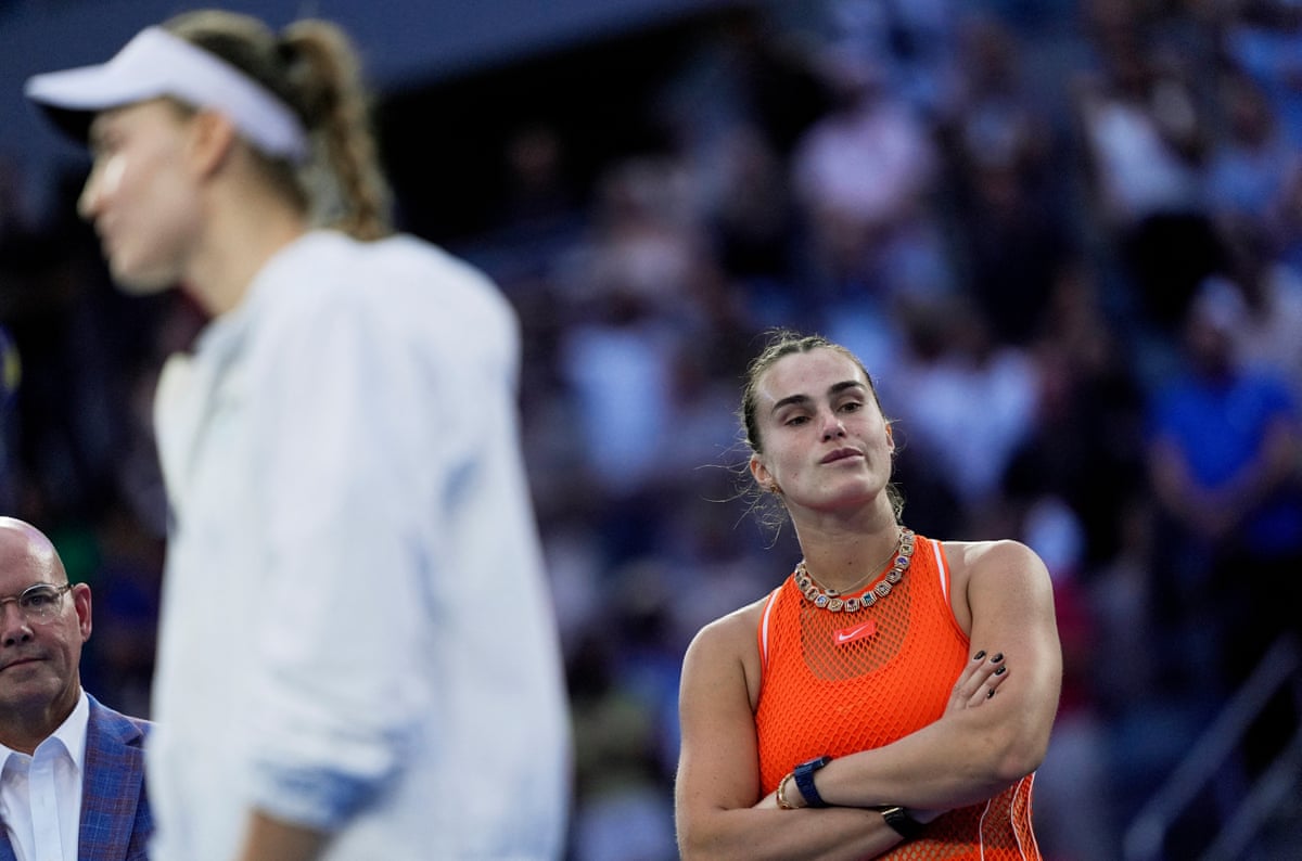Aryna Sabalenka looks dejected as Elena Rybakina is interviewed