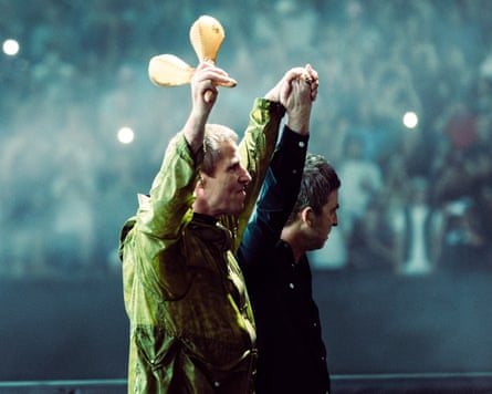 Liam and Noel Gallagher arm in arm onstage in Cardiff