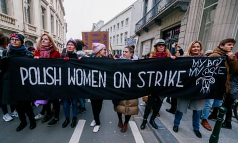 People hold banners while they take part in a rally during the International Women’s Day in Brussels, Belgium.