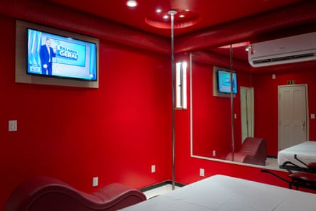 a pole dance bar next to a bed in a red room