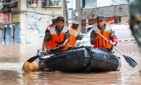 Paramilitary policemen search an area after it was flooded by heavy rains in China's southwestern Chongqing.
