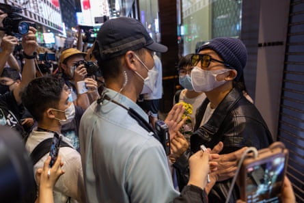 Police check mourners during a vigil for the victims of a deadly fire in Urumqi, in Hong Kong on 28 November 2022.