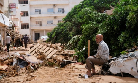 A man sits amid the flood damage in Derna, Libya