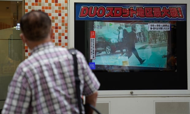 A man looks at a screen broadcasting the news of the shooting of Shinzo Abe in Nara