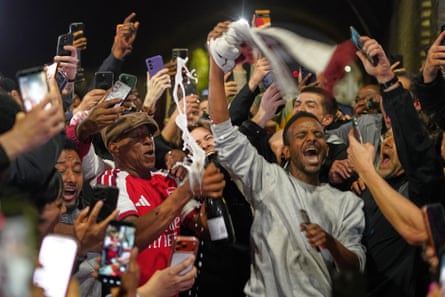 Ian Wright opens a bottle of fizz as he revels in Arsenal’s title victory with fans
