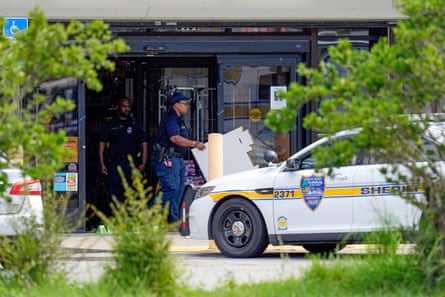 Law enforcement officials remove items from a Dollar General store, on Sunday, at the scene of a mass shooting, in Jacksonville, Florida.