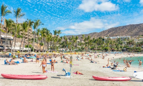 Tourists basking in glorious sunshine on Anfi beach on Gran Canaria