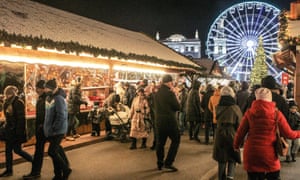 Personas en un mercado navideño en la plaza Kontraktova en Kiev, Ucrania, el 26 de diciembre.  Una gran noria se encuentra en el fondo.