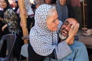 An old woman holds a crying man in her arms