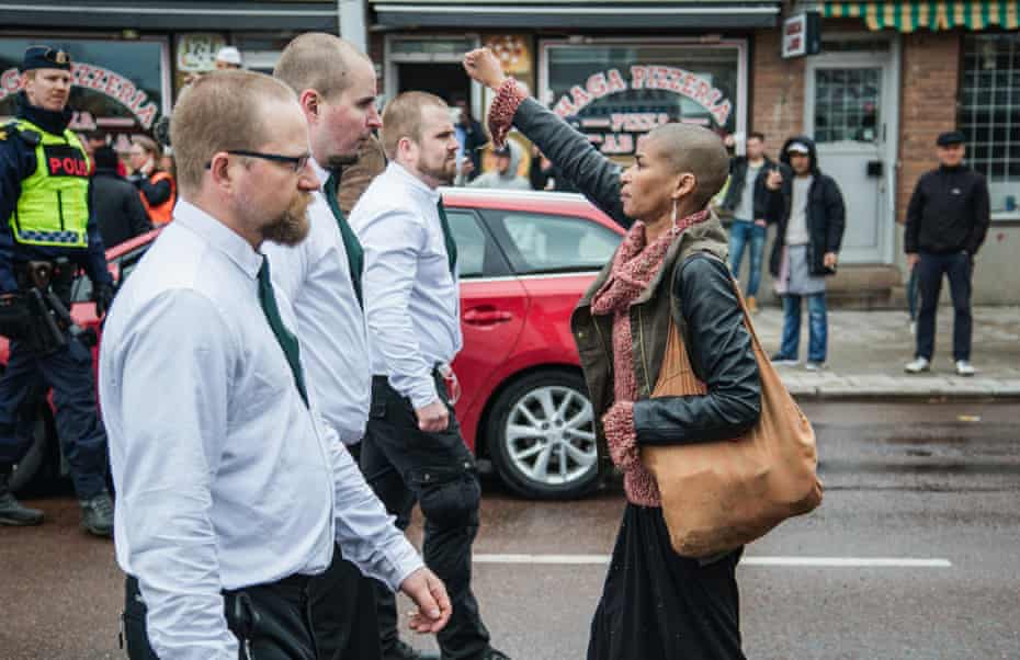A lone woman stands with raised fist opposite the uniformed demonstrators in Sunday’s Nazi demonstration in Borlange, Sweden.