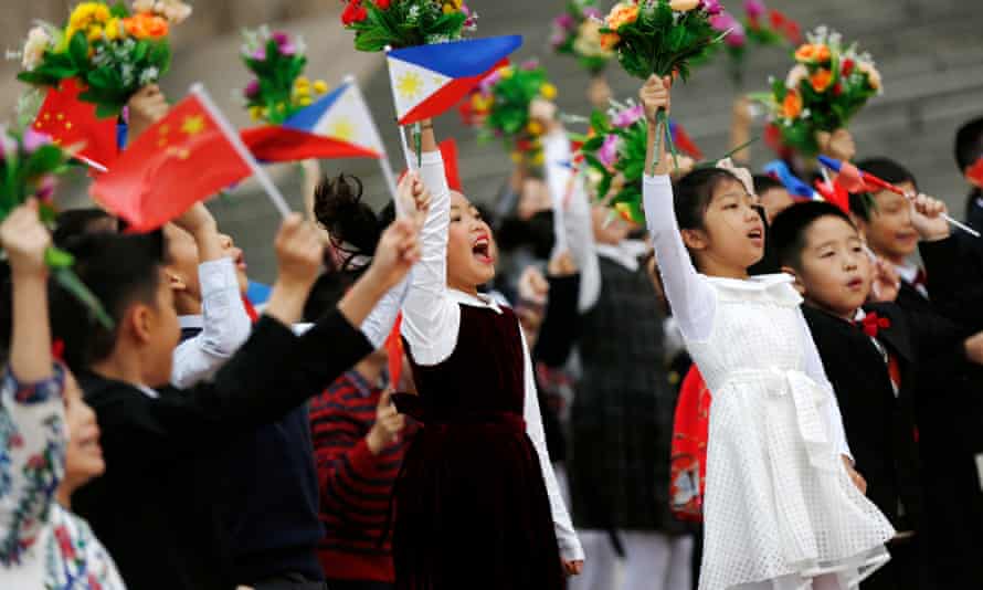 Chinese children cheer and wave Chinese and Philippines national flags and bouquets of flowers for the welcome ceremony for Rodrigo Duterte.