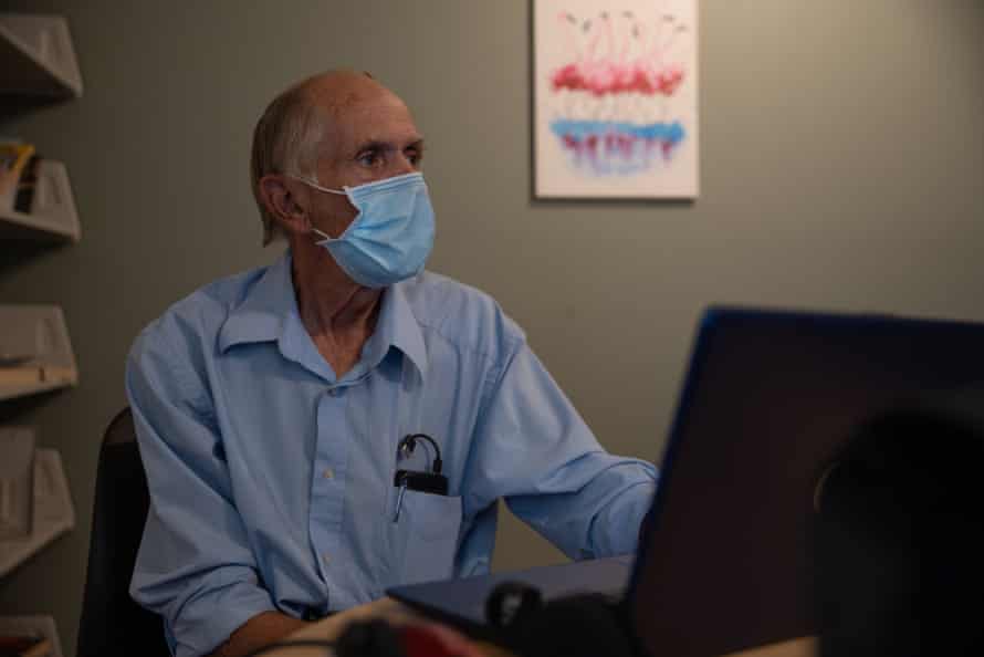 Clayton Hatfield, 69, watches a WWII documentary on his computer at the Justa Center, a support center for unsheltered elders in The Zone, an encampment where conservative estimates say 900 unsheltered people stay, during an excessive heat warning where the temperature reached 114°F on June 11, 2022 in Phoenix, Ariz.
