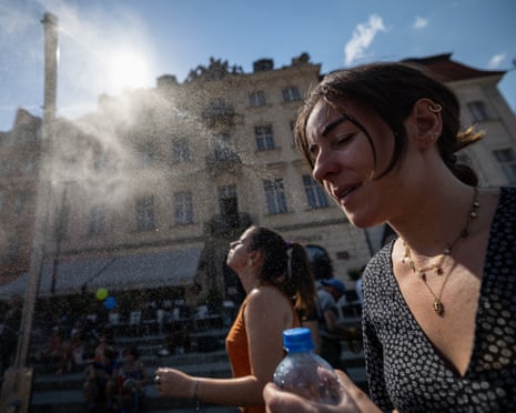 Women cools off under a water spray on the Royal Castle Square in Warsaw’s Old Town as thermometers show record temperatures during a heatwave that has reached Poland.