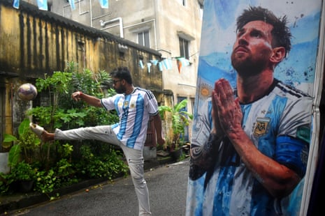 An Argentina supporter in India next to a Lionel Messi cutout.
