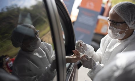 A health worker collects a blood sample at a drive-through test site in Niteroi, Brazil.