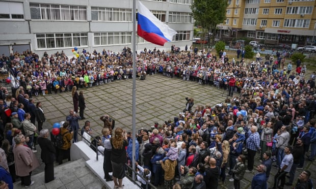 Pupils and staff take part in a flag-raising ceremony in Nakhabino, Russia
