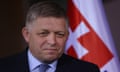 The Slovakian prime minister, Robert Fico, speaks to the media in front of a Slovakian flag