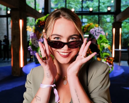 A smiling Brooks holds her Meta glasses just below her eyes