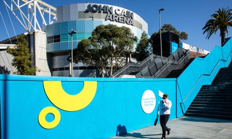 A man walks by an Australian Open sign at Melbourne Park. Ticket sales will be limited for the year’s opening grand slam due to a surge in Omicron cases.