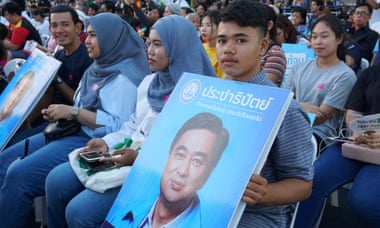 THAILAND-POLITICS-VOTESupporters of Democrat Party leader Abhisit Vejjajiva. hold his portrait during a televised election debate.