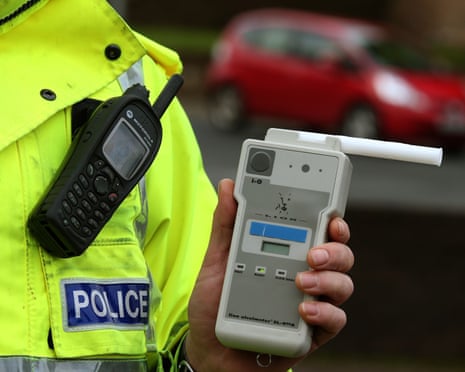 Road traffic constable holding a breathalyser