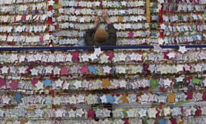 A woman hangs paper notes bearing her New Year wishes outside the Jogyesa Buddhist temple in Seoul, South Korea, Monday, Dec. 31, 2018.