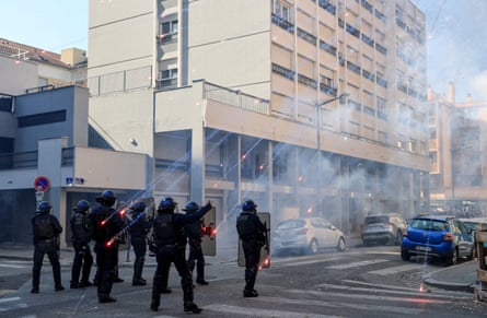 Lit fireworks rain down on riot police.
