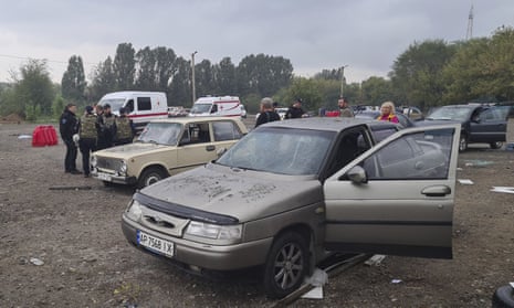 Police officers and medical workers work near damaged cars after a Russian rocket attack in Zaporizhzhia.