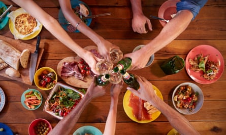 Friends making a toast at a dinner table, overhead