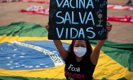 A woman with a placard reading ‘vaccine saves lives’ at a protest against Jair Bolsonaro