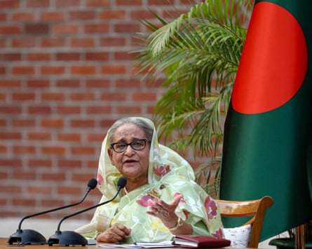Sheikh Hasina, with the flag of Bangladesh behind her as she makes an address