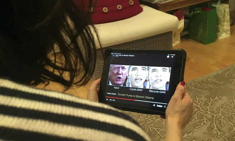 A woman watches a deepfake video of Donald Trump and Barack Obama.