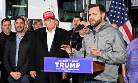 Former president Donald Trump stands in the background as senator JD Vance speaks about the recent derailment of a train carrying hazardous waste.