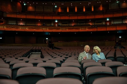 King Charles and Queen Camilla sit in an empty theatre
