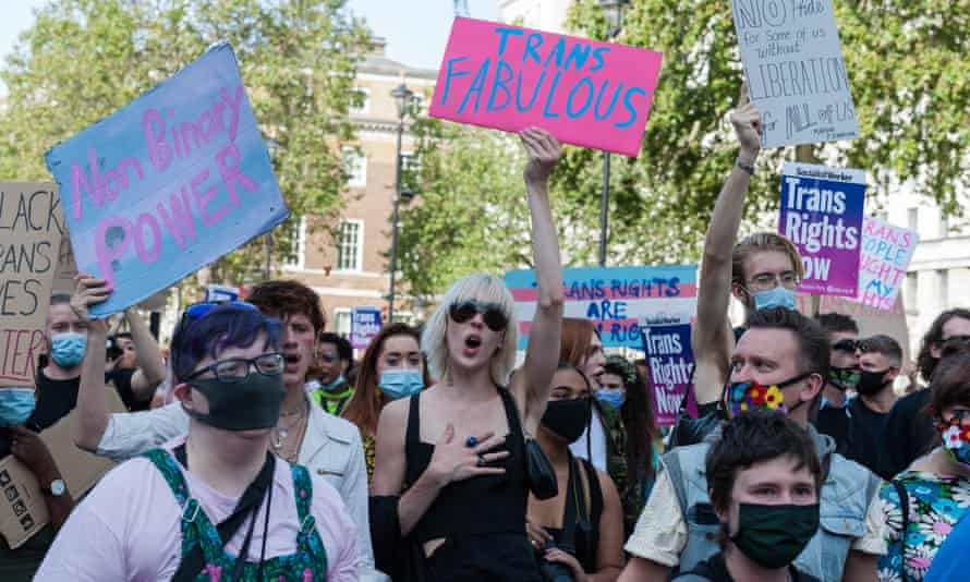 People hold posters that read Trans Fabulous and other slogans