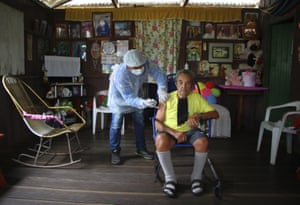 Elfiginio Euzebio de Matos, 93, right, receives a dose of the Oxford-AstraZeneca Covid-19 vaccine from a healthcare worker in the Mabedery community along the Purus Rriver, in the Labrea municipality, Amazonas state, Brazil, Friday, on 12 February, 2021.